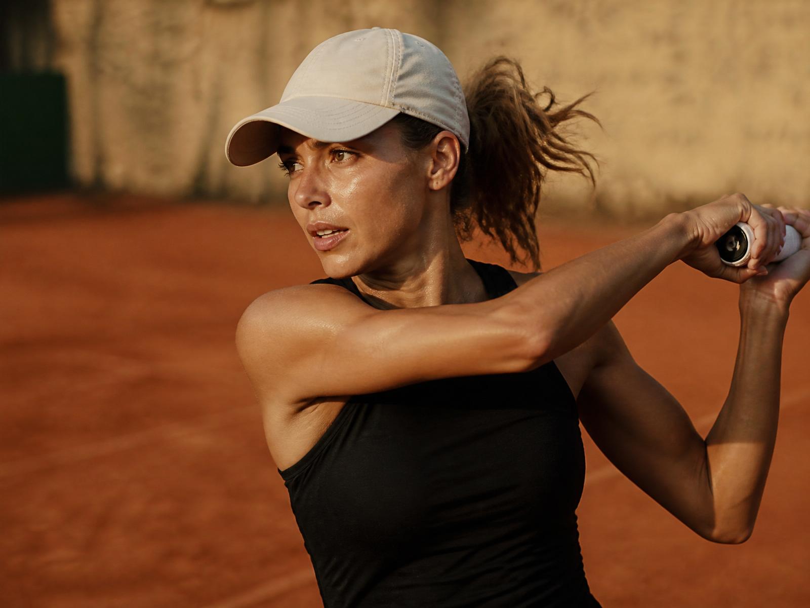 Tennis player finishing a swing at last light in a NOGNS PACE Air cap
